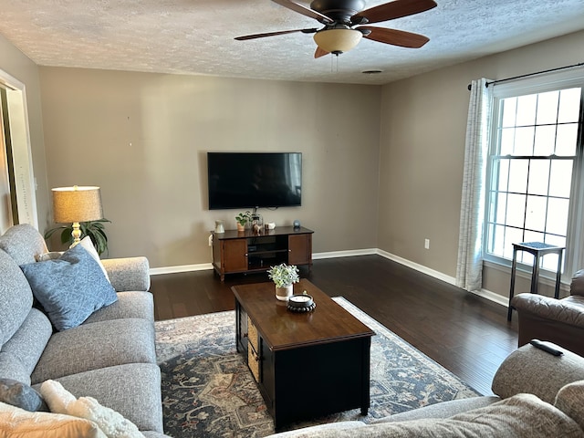 living room with ceiling fan, dark hardwood / wood-style floors, and a textured ceiling