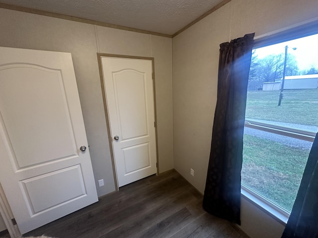 spare room with dark wood-type flooring and a textured ceiling