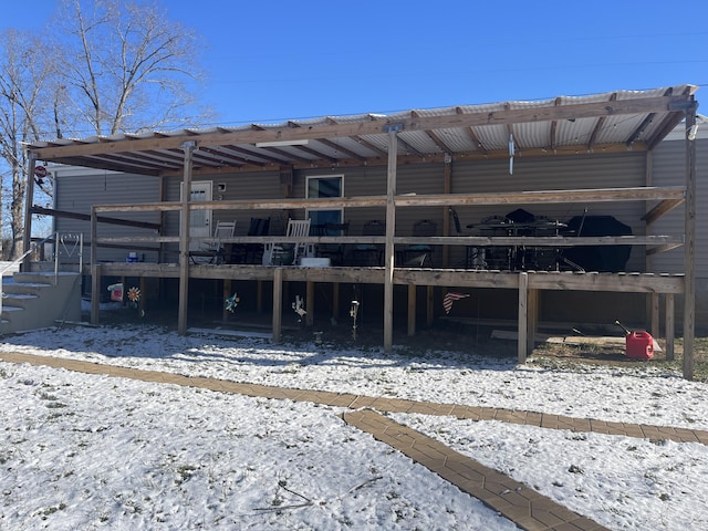 snow covered rear of property featuring a wooden deck