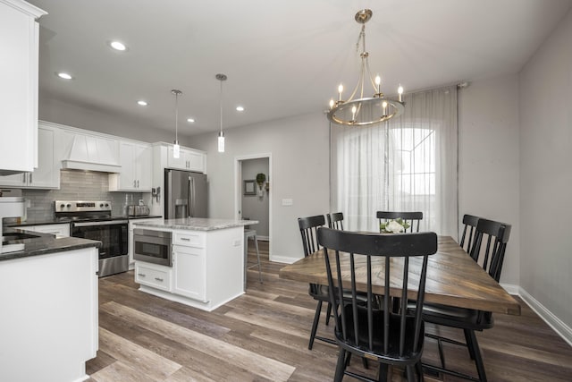 kitchen with stainless steel appliances, a center island, pendant lighting, and white cabinets