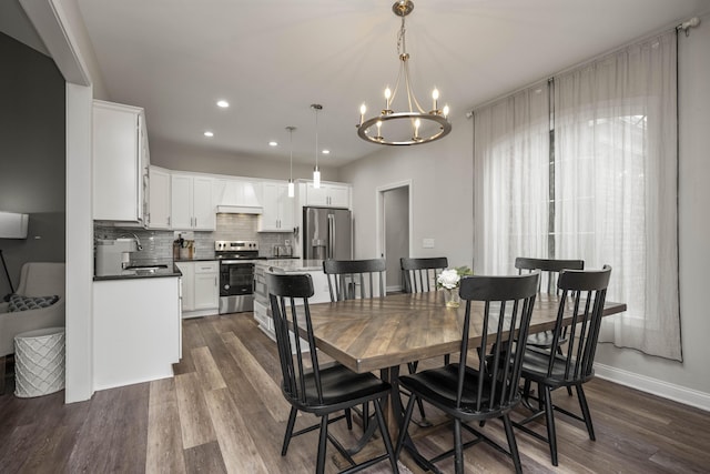 dining area featuring dark hardwood / wood-style flooring, sink, and a notable chandelier