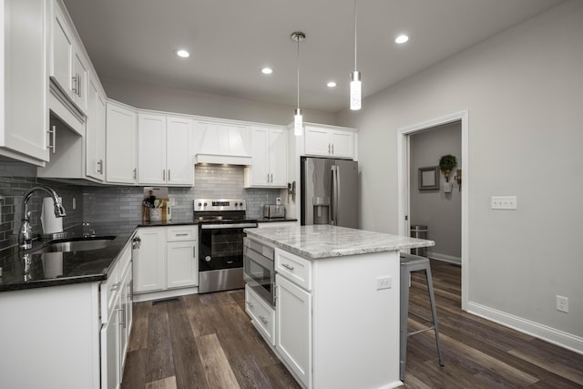 kitchen with white cabinetry, sink, a kitchen island, and appliances with stainless steel finishes