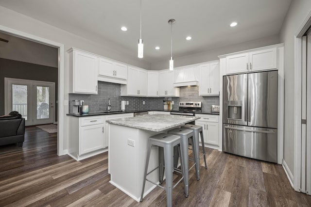 kitchen featuring sink, custom exhaust hood, decorative light fixtures, stainless steel appliances, and white cabinets