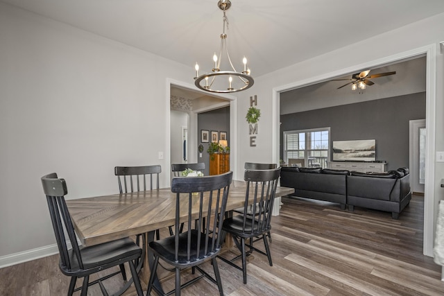 dining area with hardwood / wood-style flooring and ceiling fan with notable chandelier