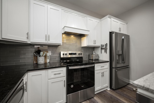 kitchen with white cabinetry, custom exhaust hood, stainless steel appliances, and dark stone counters