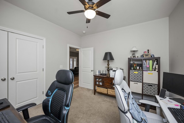 carpeted office space with ceiling fan