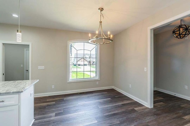 unfurnished dining area with dark hardwood / wood-style flooring and a notable chandelier