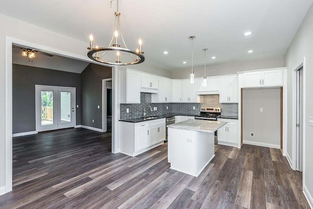 kitchen with appliances with stainless steel finishes, hanging light fixtures, and white cabinets