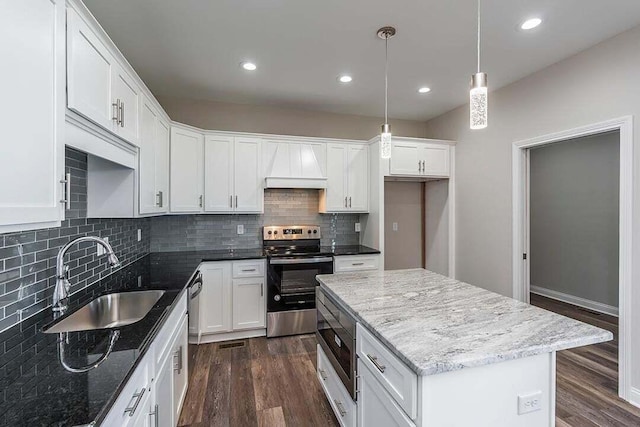 kitchen with white cabinetry, custom range hood, dark stone countertops, and appliances with stainless steel finishes