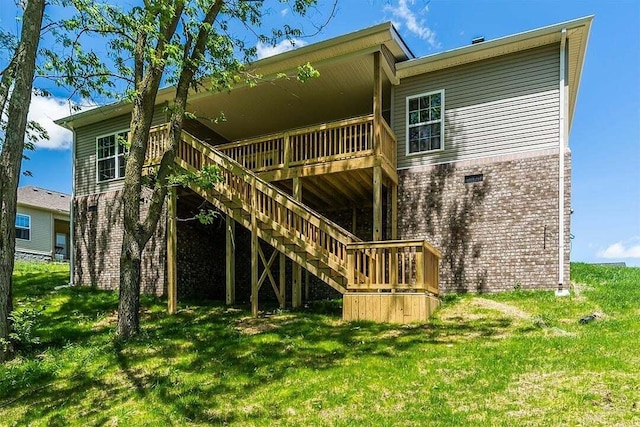 back of house with a wooden deck and a lawn