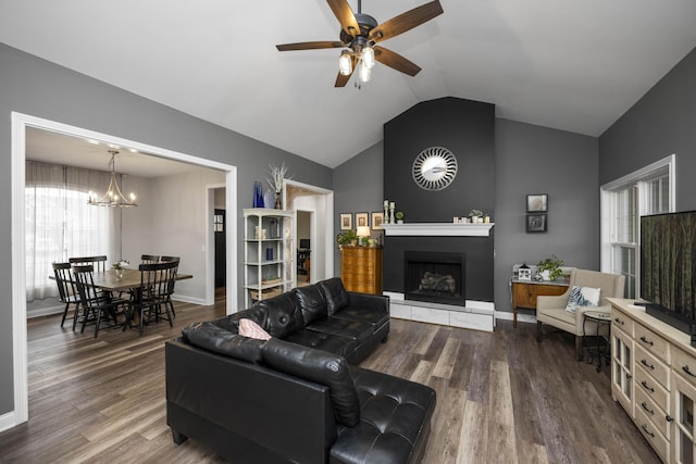 living room with vaulted ceiling, a large fireplace, ceiling fan with notable chandelier, and hardwood / wood-style floors