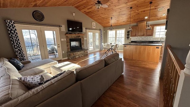 living room featuring wood ceiling, vaulted ceiling, dark hardwood / wood-style floors, ceiling fan, and a fireplace