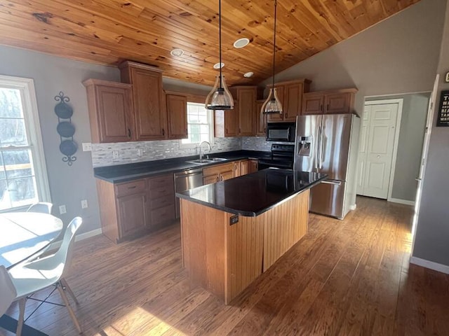 kitchen featuring sink, a center island, black appliances, decorative light fixtures, and light wood-type flooring