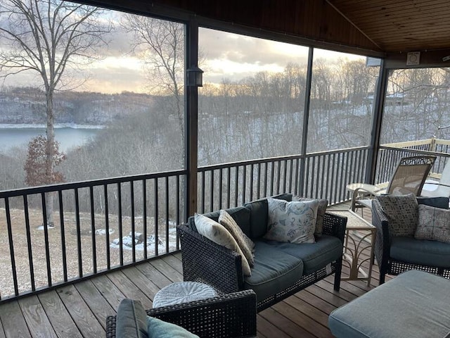 deck at dusk featuring a water view