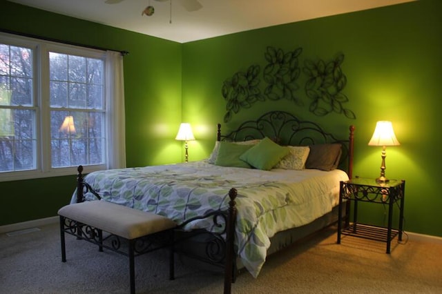 carpeted bedroom with multiple windows and ceiling fan