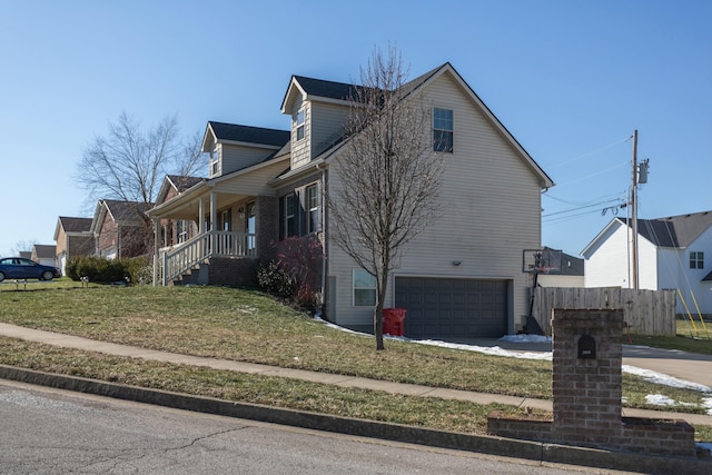 view of side of home with a porch, a garage, and a lawn