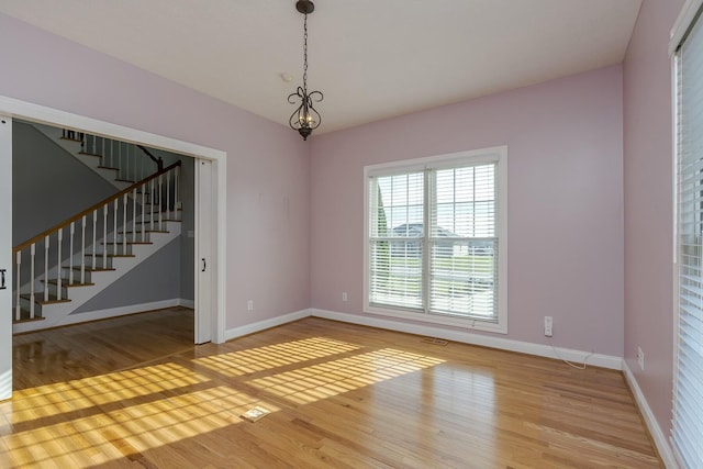 empty room featuring hardwood / wood-style floors and a notable chandelier