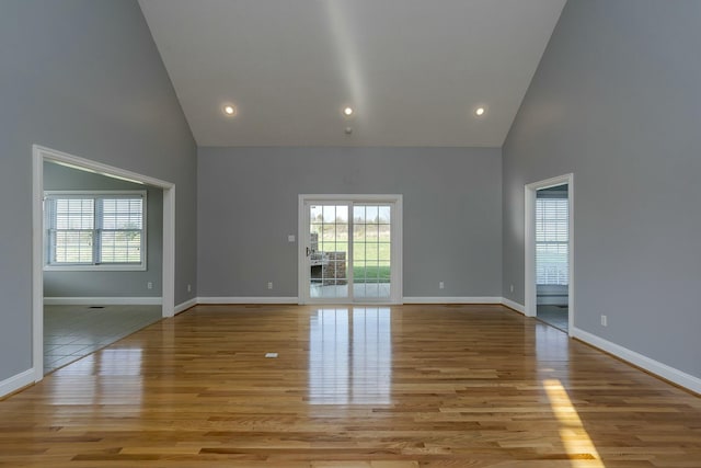 unfurnished living room with light hardwood / wood-style flooring and high vaulted ceiling