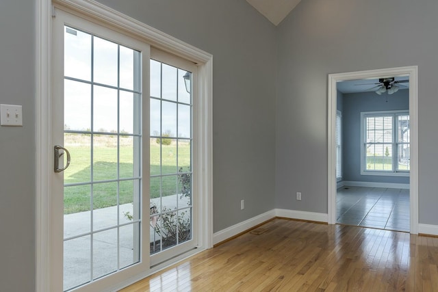 doorway to outside featuring ceiling fan, vaulted ceiling, and light hardwood / wood-style flooring