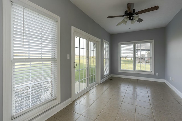 unfurnished sunroom with ceiling fan