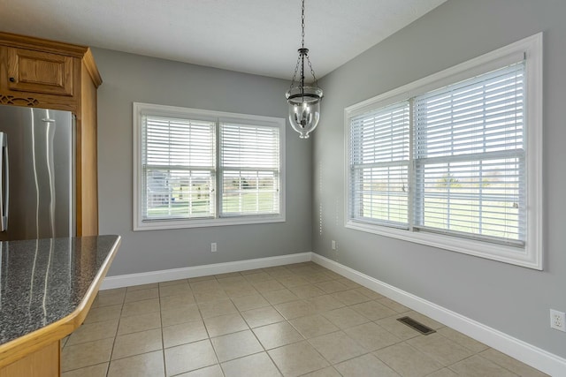 unfurnished dining area featuring light tile patterned flooring