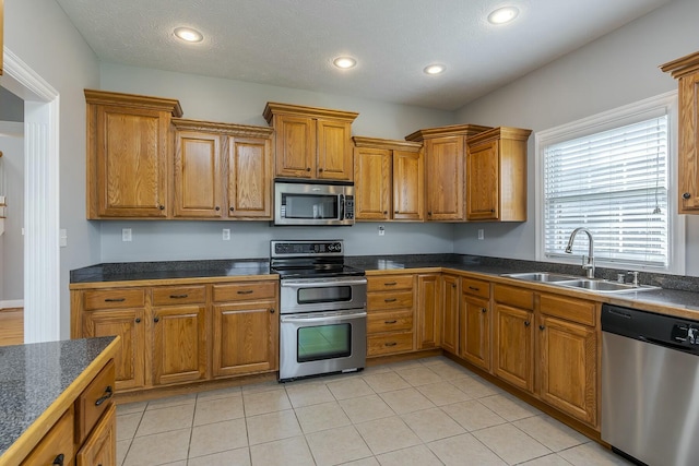 kitchen featuring light tile patterned floors, appliances with stainless steel finishes, and sink