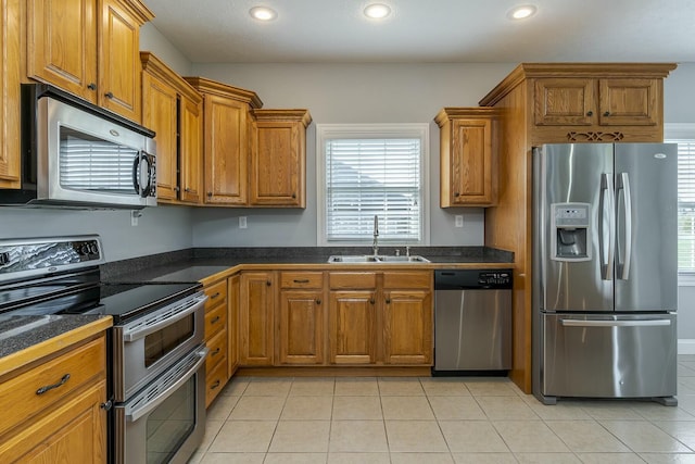 kitchen with light tile patterned floors, stainless steel appliances, and sink