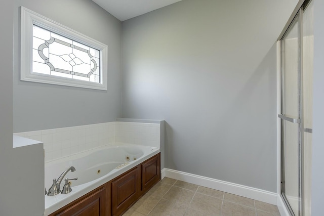 bathroom with a washtub and tile patterned flooring