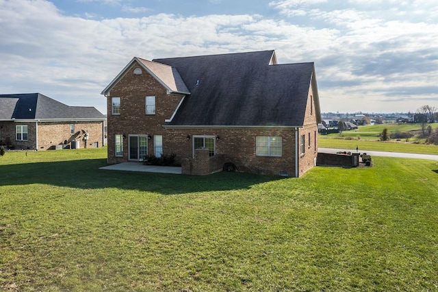 rear view of property featuring a lawn and a patio