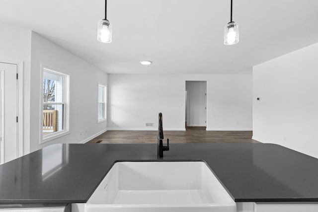 kitchen featuring open floor plan, decorative light fixtures, a sink, and visible vents