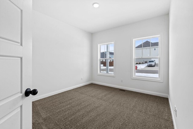 unfurnished bedroom with dark carpet and a closet