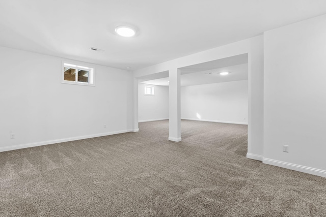 below grade area featuring carpet, visible vents, and baseboards