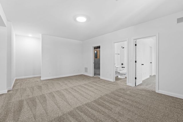 unfurnished bedroom featuring baseboards, carpet flooring, visible vents, and connected bathroom