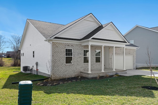 view of front of home featuring a garage, driveway, covered porch, central AC, and a front yard