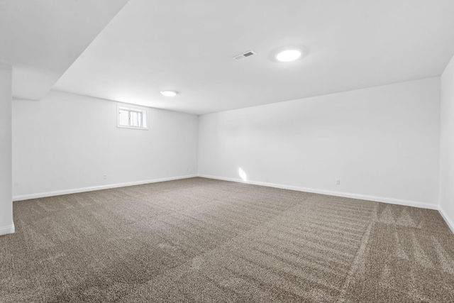 carpeted spare room featuring visible vents and baseboards