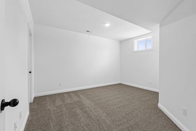 below grade area featuring carpet, visible vents, and baseboards