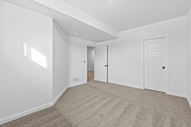 empty room featuring carpet floors, baseboards, and visible vents