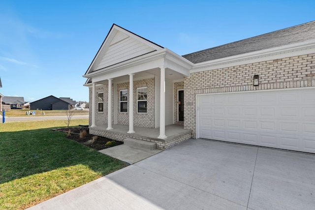 view of front of home with brick siding, covered porch, an attached garage, a front yard, and driveway