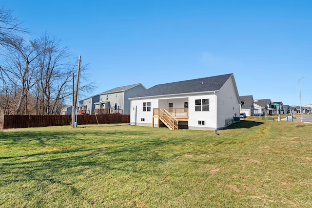 rear view of house featuring a residential view, stairs, fence, and a yard