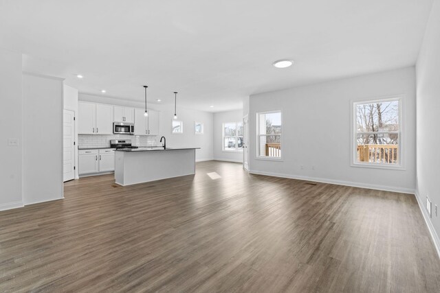 unfurnished living room featuring dark hardwood / wood-style floors and sink