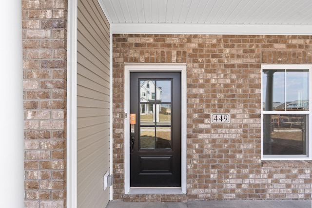 doorway to property featuring brick siding