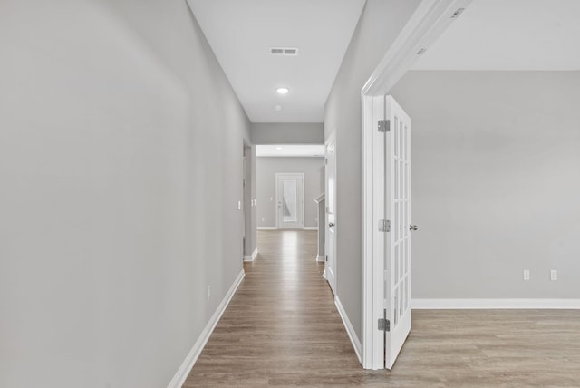 hallway with visible vents, recessed lighting, light wood-type flooring, and baseboards