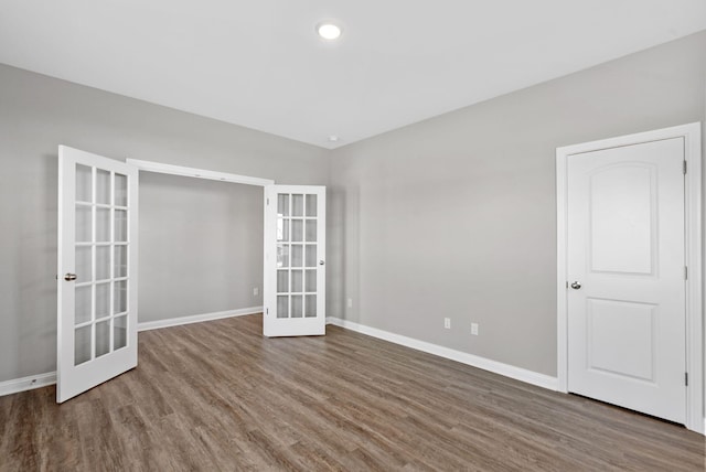 empty room featuring french doors, baseboards, and wood finished floors