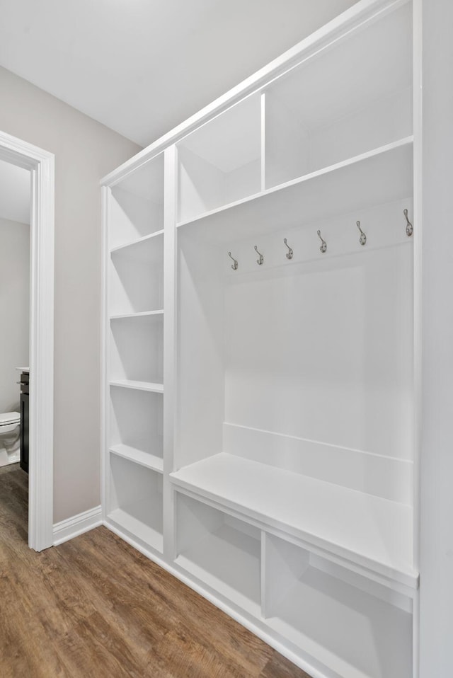 mudroom featuring baseboards and dark wood-type flooring