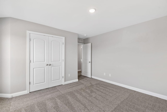 unfurnished bedroom with carpet, baseboards, and a closet