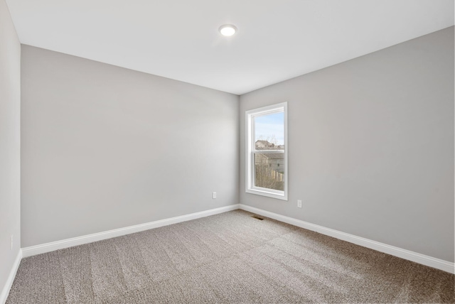 empty room featuring visible vents, carpet, and baseboards