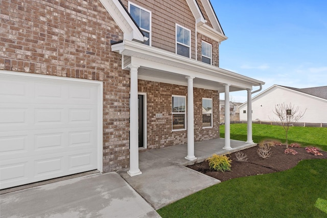 entrance to property featuring brick siding, covered porch, and an attached garage