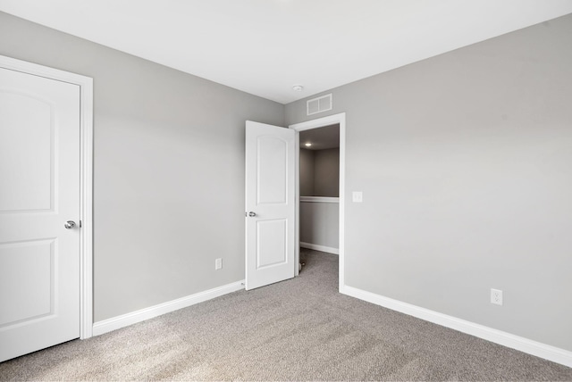 unfurnished bedroom with visible vents, baseboards, and carpet