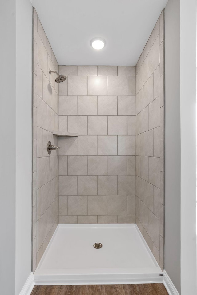 bathroom featuring baseboards and tiled shower