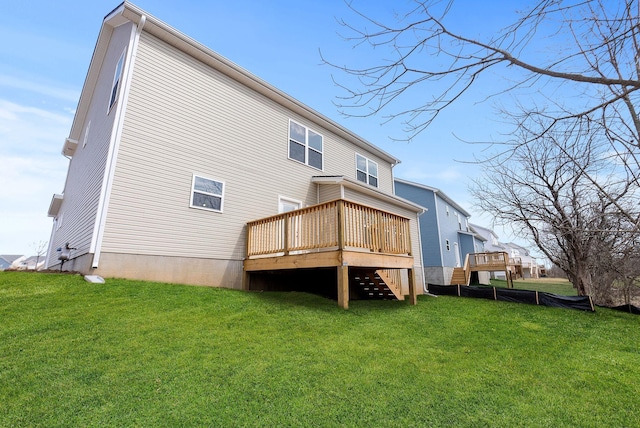 rear view of property featuring a wooden deck and a yard